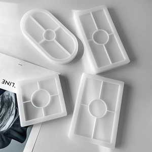 Macro view of four geometric silicone resin molds for DIY trays and coasters on white background