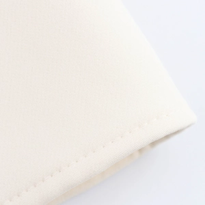 Macro shot of cream white textile fabric texture with detailed stitching and woven pattern
