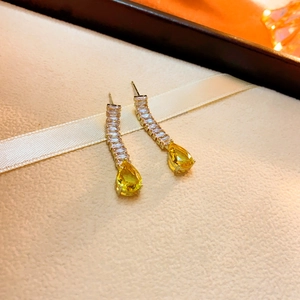 Vue détaillée des boucles d'oreilles en pierres jaunes avec incrustation de zircons
