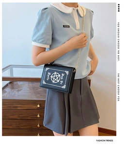 Model wearing a vintage Book Of Spells punk style crossbody bag with gold chain strap
