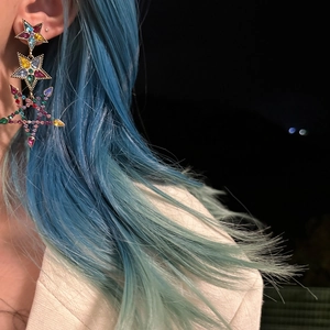 Detail shot of multi-layer colorful star tassel earrings with vibrant crystals