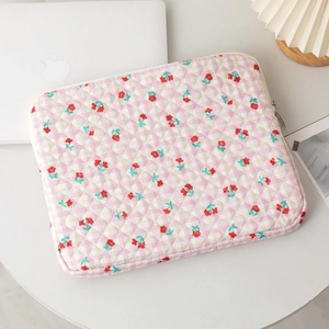 Detailed view of quilted laptop sleeve with floral pattern and secure metal zipper