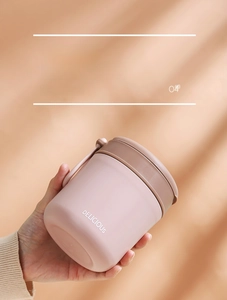 Handheld view of a portable pink 304 stainless steel soup cup with handle and text detail