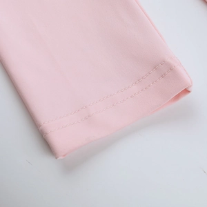Détail du tissu en maille rose montrant les finitions de couture à double aiguille