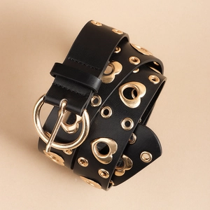 Close-up of black leather belt featuring gold heart-shaped eyelets and round pin buckle