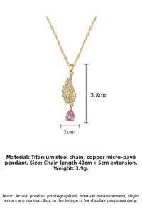 Macro detail of angel wing pendant with pink teardrop stone and gold chain dimensions