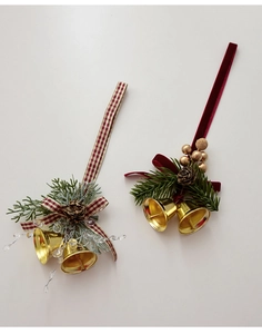 Close-up of gold Christmas bells with pine cones, red velvet ribbons and berries