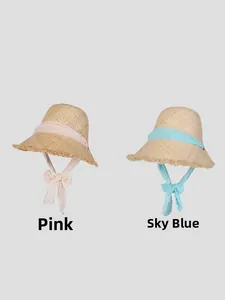 Detail of pink and sky blue polka dot ribbons on handwoven raffia sun hats with frayed edges