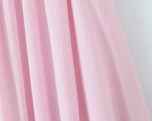 Detailed macro view of pink and white striped seersucker fabric texture and cotton weave