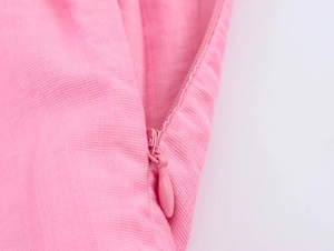 Dettaglio di un abito francese rosa che mostra la cerniera invisibile e il tessuto lino