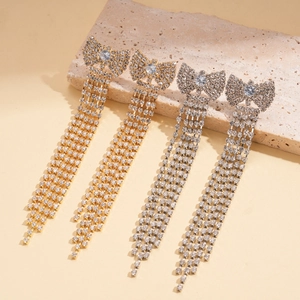 Dettaglio di orecchini a fiocco in zircone con frange di strass in oro e argento