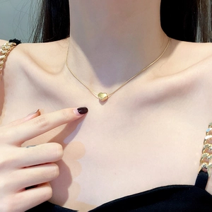 Minimalist gold titanium steel heart pendant necklace on female model neck