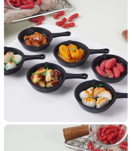 Macro detail of miniature dollhouse frying pan with realistic fake food and fried dumplings