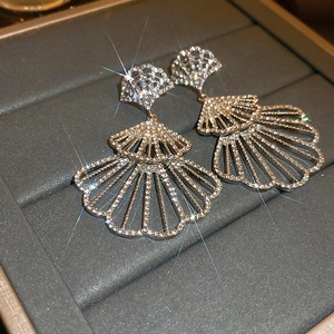 Close-up of silver fan-shaped skirt earrings with sparkling full-set rhinestones