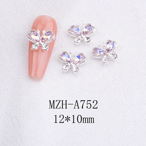 Detailed view of silver butterfly nail charms with purple rhinestones on nails