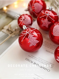 Macro shot of glossy red Christmas balls with white painted tree and star patterns