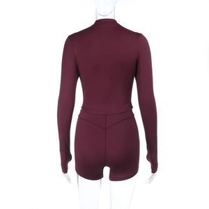 Rear view of burgundy two-piece yoga set with long sleeve crop top and booty shorts