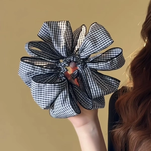 Close-up of black and white vichy check scrunchie showing fabric texture and layers