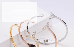 Detail view of stylish dolphin tail bangles with pavé rhinestones in gold and silver
