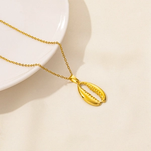 Detailed view of a gold starfish shell pendant necklace on a beige textured cloth