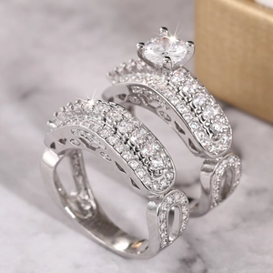 Macro shot of silver wedding rings with four-prong set cubic zirconia and pavé band