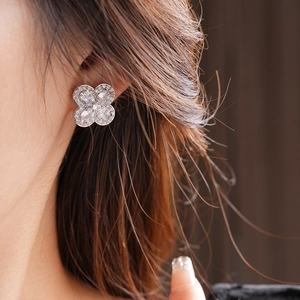 Gros plan d'une boucle d'oreille trèfle en argent avec cristaux sur un mannequin