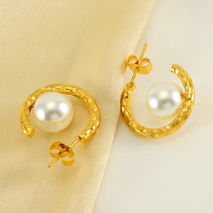 French vintage hammered gold C-shaped earrings with white pearls on silk background
