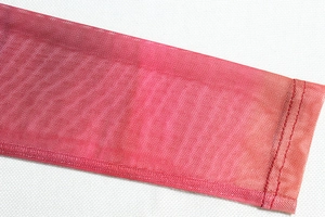 Macro shot of red pink gradient mesh fabric showing precise stitching on the hem