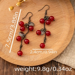 Detail view of red beaded teardrop earrings with dimensions 7.5cm and 9.8g weight