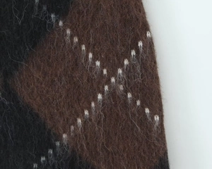 Detailed close-up of brown and black argyle knit fabric showing soft mohair texture