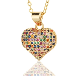 Macro shot of gold heart pendant necklace featuring colorful rainbow zircon stones