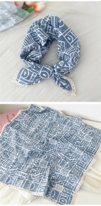 Detail of blue geometric cotton linen scarf with lace edges and soft floral accents