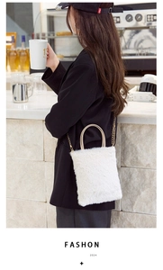 Detail of plush faux fur crossbody bag with golden ring handle in a cafe setting