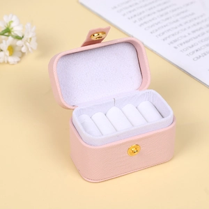 Pink PU leather mini portable jewelry box for rings and earrings on beige table