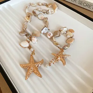 Elegant beaded ocean necklace with shell pearls and golden starfish charms on white texture