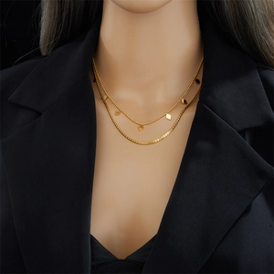 Collier double épaisseur en or avec pendentifs losanges portés sur le cou d'un mannequin