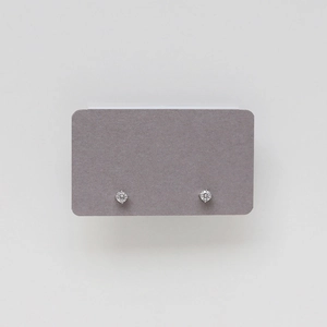 Detail of silver titanium steel stud earring featuring a classic four-prong cubic zirconia setting