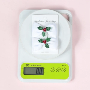 Pair of white Christmas holly bow hair clips on cardstock, weighing approx 8.0 grams