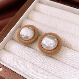 Elegant vintage brown velvet round stud earrings with pearl center in a wooden jewelry box