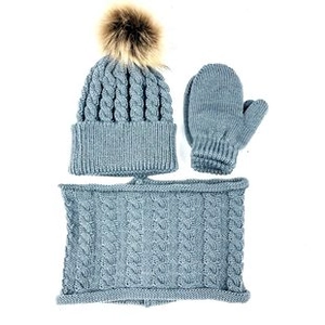 Dettaglio della maglia a trecce e pompon sul set invernale azzurro