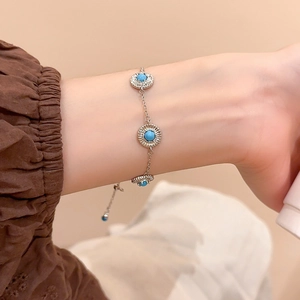 Détail d'un bracelet géométrique argenté avec charmes turquoise et cristaux pavés