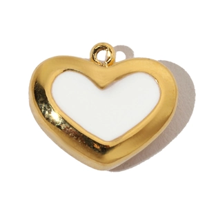 Detailed view of heart pendant with gold plated edge and white enamel center inlay