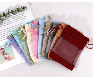 Detail of colorful drawstring linen pouches with organza windows for jewelry storage