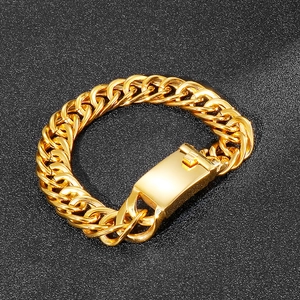 Chunky gold Cuban chain bracelet for men with secure box clasp on textured black background