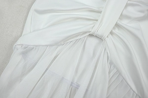 Detail of white two-piece set featuring mesh patchwork and twisted fabric design