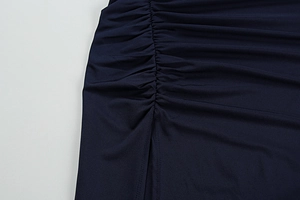 Detailed view of navy ruched fabric and side slit design on a slim fit bodycon dress