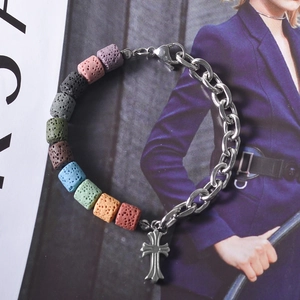 Macro detail of multicolored lava stone beads and silver cross pendant on link chain