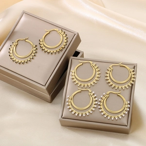 Detailed view of vintage gold double-layer hoop earrings with pearls and black beads