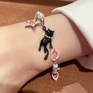 Y2K style bracelet with black cat pendant, pink star and white pearls on wrist