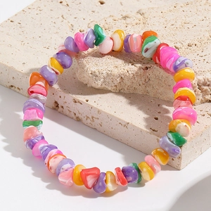 Detail shot of colorful irregular stone beads on a rustic rock, bohemian style bracelet